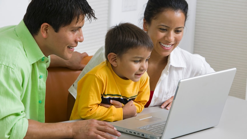 Parents and their young son, using a laptop computer