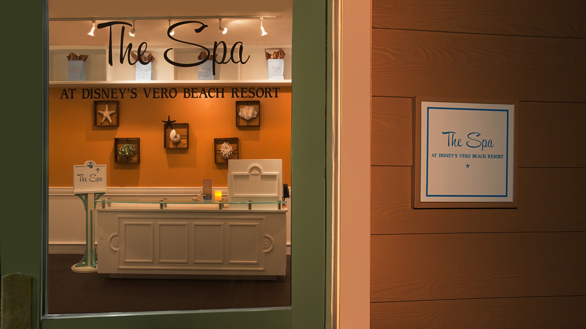 The front desk of a spa, and 2 signs reading