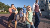 A family of 5 with a Disney VIP Tour Guide, walking by Cinderella Castle at Magic Kingdom park